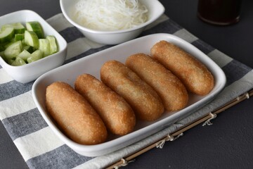 Pempek  on white plate with vermicelli and cuko sauce. Pempek, mpek-mpek or empek-empek is a savory Indonesian fishcake delicacy, made of fish and tapioca, from Palembang, South Sumatera, Indonesia.