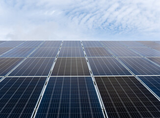 Solar power plant panels against a cloudy sky