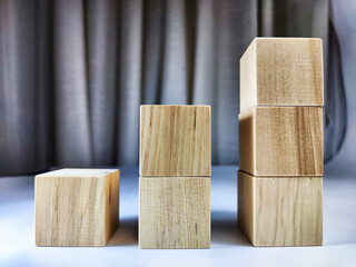 Small wooden cubes in columns, lined up in row. The concept of progressive movement in achieving the goal. Steps and stages of project development and implementation