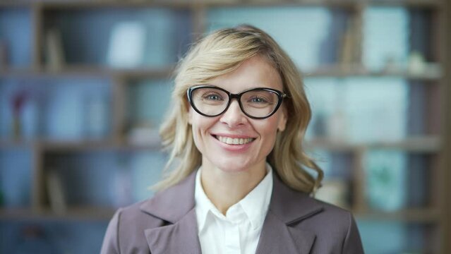 Portrait of business woman lawyer representativet or teacher Mature Independent associate professor with glasses female businesswoman owner standing in office or classroom look at camera smile indoor 