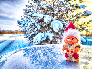 Cute little funny dwarf in the snow in the landscape in winter. A wizard on a snowy background....