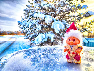 Obraz premium Cute little funny dwarf in the snow in the landscape in winter. A wizard on a snowy background. Christmas and New Year
