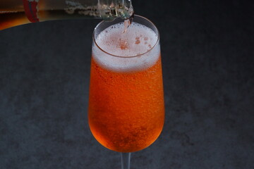 よく冷えたロゼのシャンパン（スパークリングワイン）をフルートグラスに注ぐ
 - obrazy, fototapety, plakaty