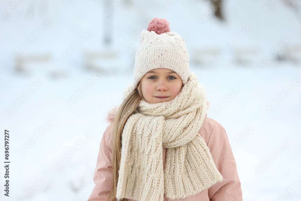 Sticker Portrait of cute little girl in snowy park on winter day