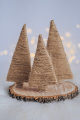 Christmas tree made of straw on a white background with bokeh.