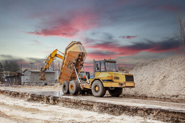 View a digger and dumper truck on a brownfield site in the construction industry. Construction...
