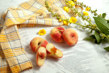 Halves and three whole saturn peaches or flat peach on white wooden background.. © kostik2photo