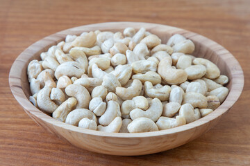 Cashews in a wooden bowl. Nuts are healthy food. Wooden background. Cashew kernel