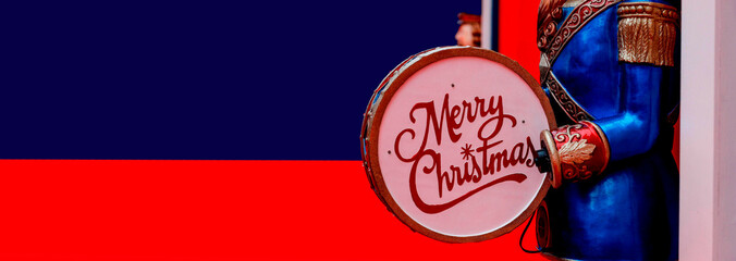 Merry Christmas greeting card, drummer soldier with dominant blue and red colors, banner format.