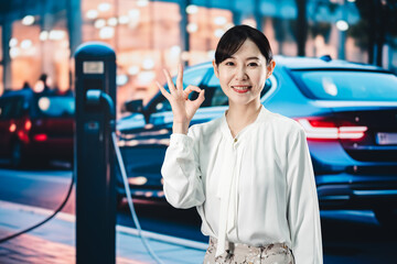 道路で電気自動車を充電する女性
