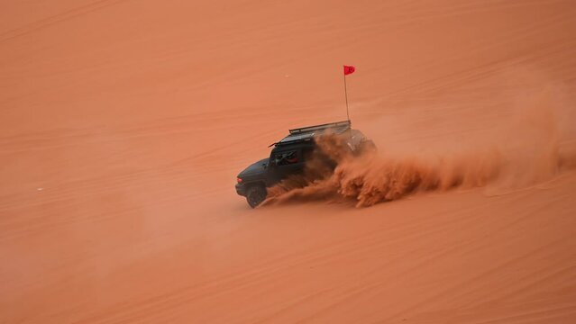 Riyadh, Saudi Arabia – November 1st 2023: Offroad vehicles bashing and climbing desert safari dunes ,red sand dunes adventurous ride 4x4 vehicle in Riyadh. Modified car, customized vehicle