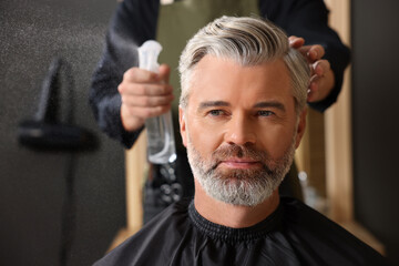 Hair styling. Professional hairdresser working with client in barbershop, closeup