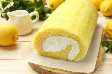 Delicious cake roll on light wooden table, closeup