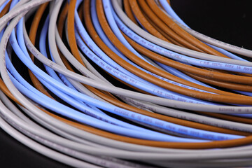 Electrical installation wires in colored insulation on a dark background. Close-up.