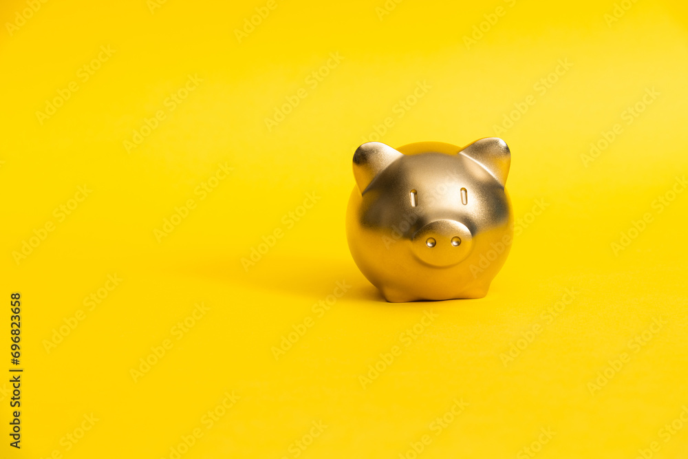 Wall mural piggy bank on yellow background