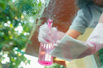 Housekeeper cleaning glass With cleaning solution and tissue towel