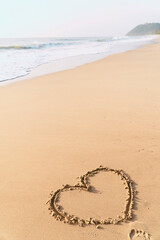 Hand draw a heart shape on the sandy beach in the morning. love and emotional. to welcome the Valentine's Day festival.