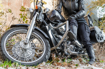 girl in leather biker jacket and black boots on a chopper motorcycle