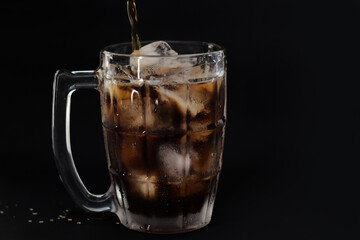 Clear glass with ice and nectar on a gray-black background.