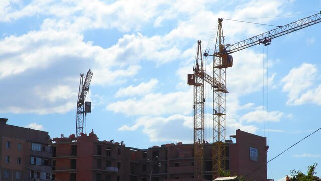 Home construction. Working crane on the construction of the house. Construction site with cranes on sky background.