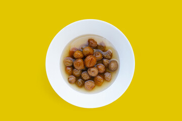 Pickled plums on yellow background.
