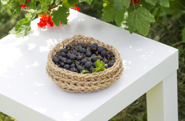 Juicy ripe berries of a gooseberry in a small handmade jute basket.