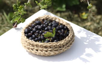 Juicy ripe berries of a gooseberry in a small handmade jute basket.