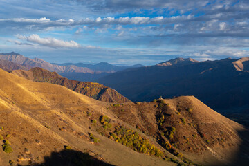 mountainous landforms at sunset meadows, warm shades of autumn mountains