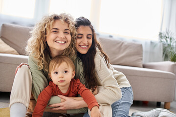 Fototapeta premium attractive jolly lgbt couple having great time together with their daughter at home, family concept