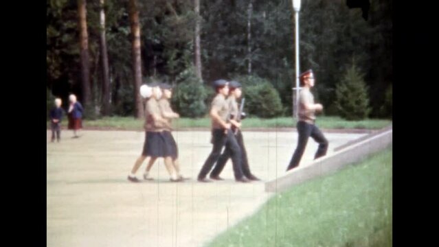 Pioneer children salute to soldiers of Second World War memorial. People soldier marching, saluting. Military holiday. Patriotism in remember, honor. Retro archival film. 1980s Russia. Vintage archive