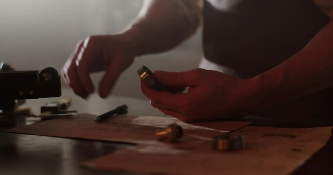 Silhouette of workman measuring detail in darkness