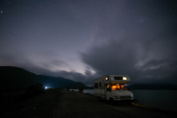 motor home in a mountainous area, on the shore of a reservoir
