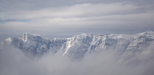 Snowy mountains above the clouds in a beautiful winter landscape