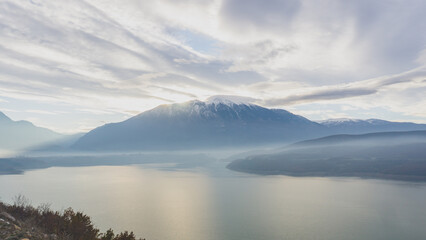 Obraz premium Beautiful lake during sunrise with the mountains at the background