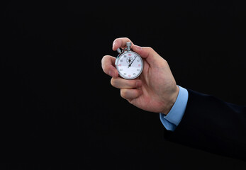 Businessman hand holding stopwatch on black background
