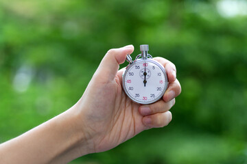 People hand holding stopwatch outdoors