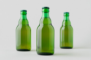 Green steinie beer bottle mockup on a grey background.