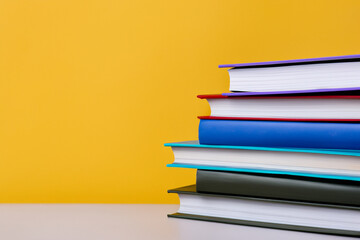 stack of colorful books. textbooks stacked on top of each other, color background. education concept - obrazy, fototapety, plakaty