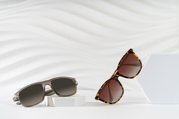Men's and women's Trendy sunglasses on podiums on a white background. Fashionable eyewear...