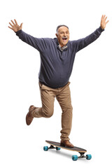Full length portrait of a crazy mature man riding a skateboard with arms up