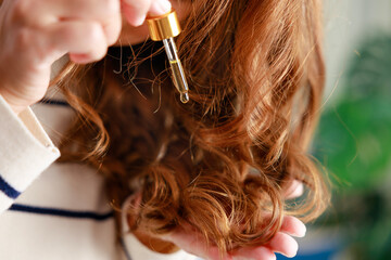 Young woman cares for her hair with cosmetic oil