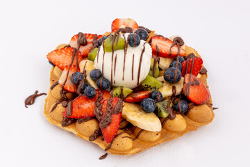 Waffle with  ice cream and fruits, chocolate sauce, fresh berries