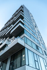 Modern building in the city. Skyscraper with balconies and large glass windows.