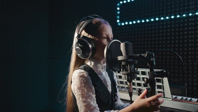 Girl during vocal lesson in recording studio
