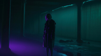 Mysterious silhouette of a woman in a dark corridor with a glowing neon light