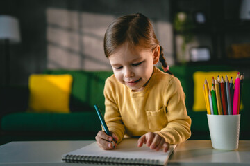 Toddler girl caucasian child play with crayons at home