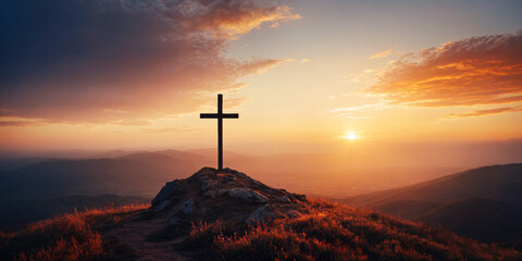 A cross on top of a hill with a sunset behind it