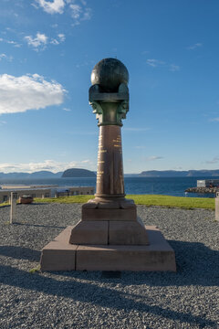 The historic Meridian Column in Hammerfest under a blue sky, UNESCO World Heritage monument celebrating the Struve Geodetic Arc, scenic coastal landscape in Northern Norway.
