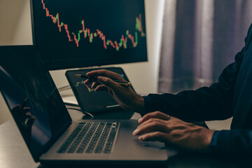 A close-up image of a businessman looking at the direction of the moving average. stock price movement Trading stocks up and down On the laptop computer display screen, finance concept © ArLawKa