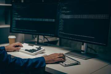 An IT programmer works on a desktop computer. Male expert creates innovative software engineer...